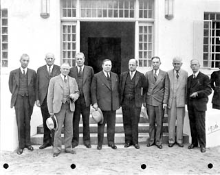 Nine men standing in front of the prison entrance.