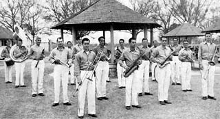 Group of approx. 15 inmates in coordinated uniforms holding band instruments.