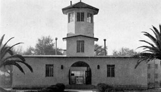 Building with entrance gate and fencing on both sides.