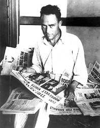 Photo of Zangara in prison uniform surrounded by newspapers.