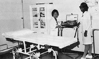 Nurses standing in medical room with gurney