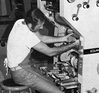 Man sitting with hands inside a machine.