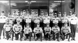 Officers in uniform standing in front of building