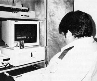 Officer sitting with back to camera looking at computer work station