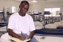 Inmate writing on a notepad