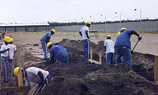 Inmates digging a foundation with wood framing